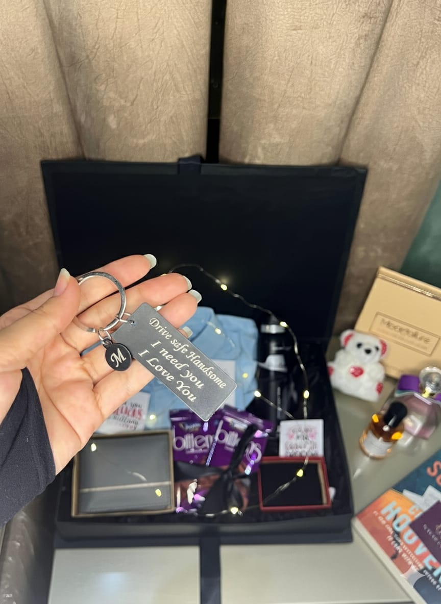 Luxury men’s gift box with blue shirt, leather wallet, engraved keychain, chocolates, mug, perfume, and fairy lights