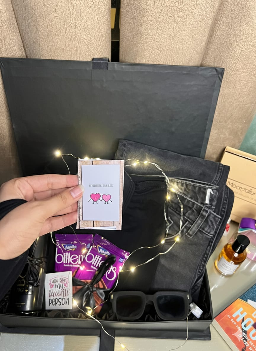 Premium men’s gift box with black polo shirt, jeans, perfume, sunglasses, mug, chocolates, and fairy lights