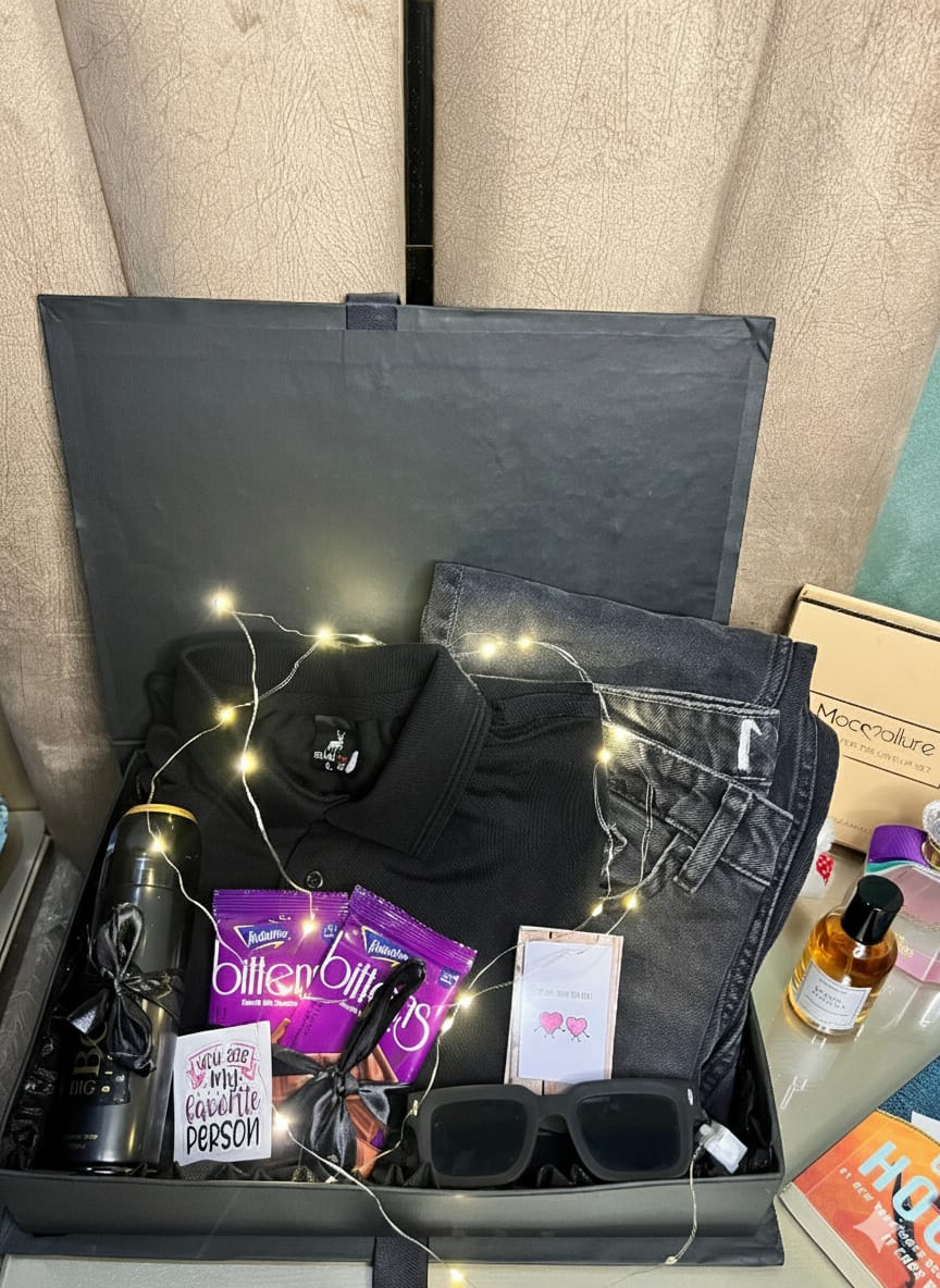Premium men’s gift box with black polo shirt, jeans, perfume, sunglasses, mug, chocolates, and fairy lights